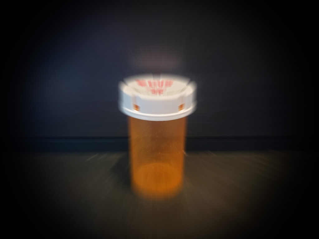 Blurred image of a plastic prescription bottle.